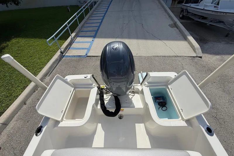 Slide: The Image of 2024 Key West 1720 Center Console boat with open storage compartments and outboard motor. - 16