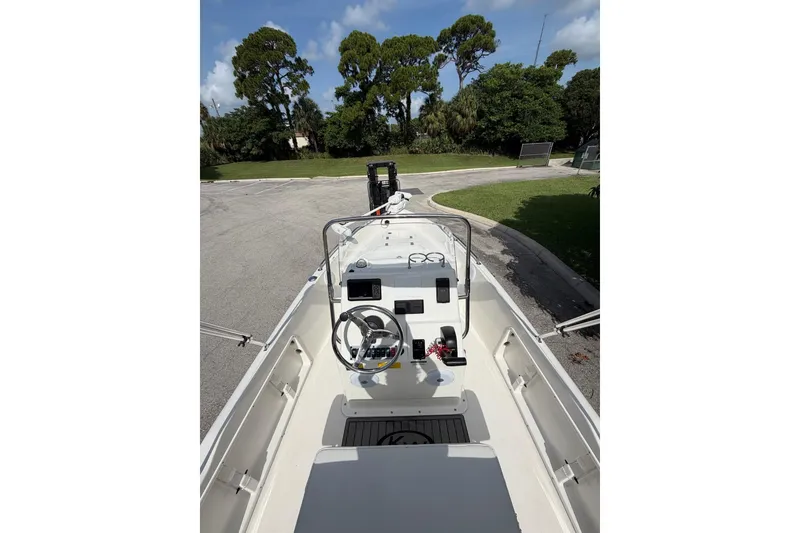 Slide: The Image of 2024 Key West 1720 Center Console boat with steering wheel and control panel, parked outdoors. - 14