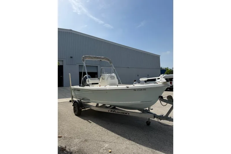 Slide: The Image of 2024 Key West 1720 Center Console boat on trailer, parked outside a warehouse. - 9