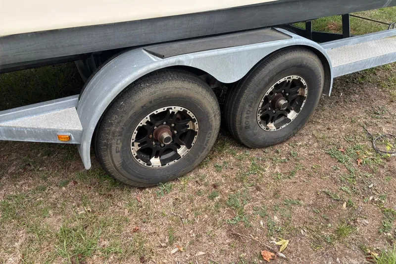Slide: The Image of Trailer wheels of a 2016 Scout 275 Dorado boat on grassy ground. - 3