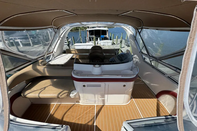 Slide: The Image of 2003 Sea Ray 45 Express Bridge interior with helm, seating, and clear canopy at dock. - 8