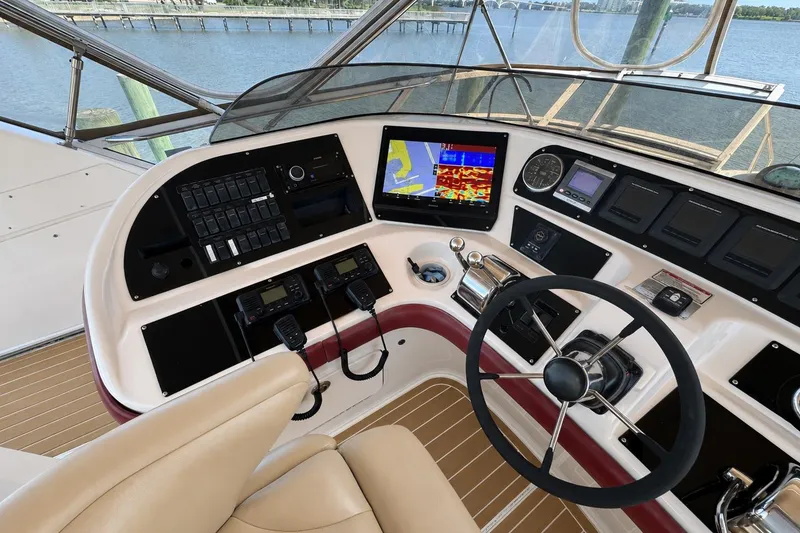 Slide: The Image of Helm of 2003 Sea Ray 45 Express Bridge with navigation controls and scenic water view. - 5