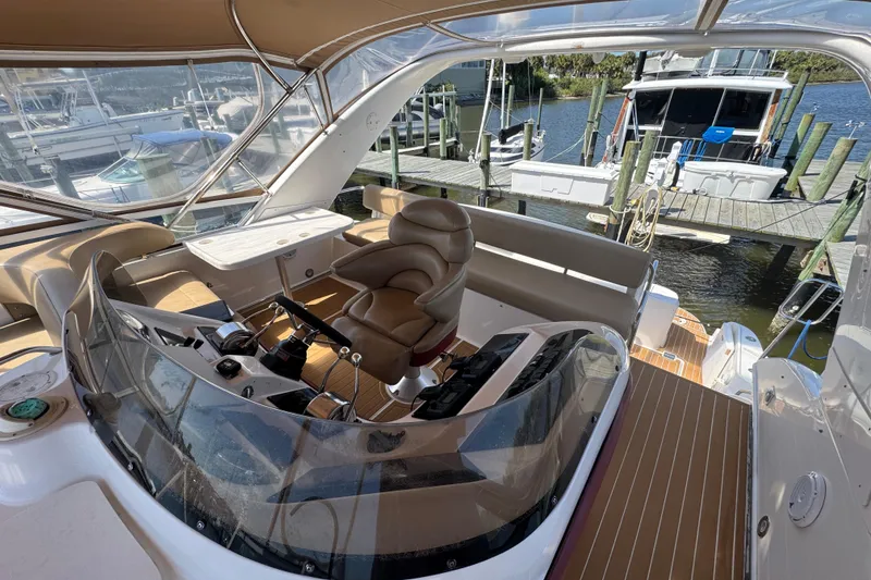 Slide: The Image of 2003 Sea Ray 45 Express Bridge helm with leather seating and marina view. - 3