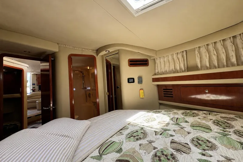 Slide: The Image of Interior cabin of 2003 Sea Ray 45 Express Bridge yacht, featuring cozy bedding and elegant wood finishes. - 14