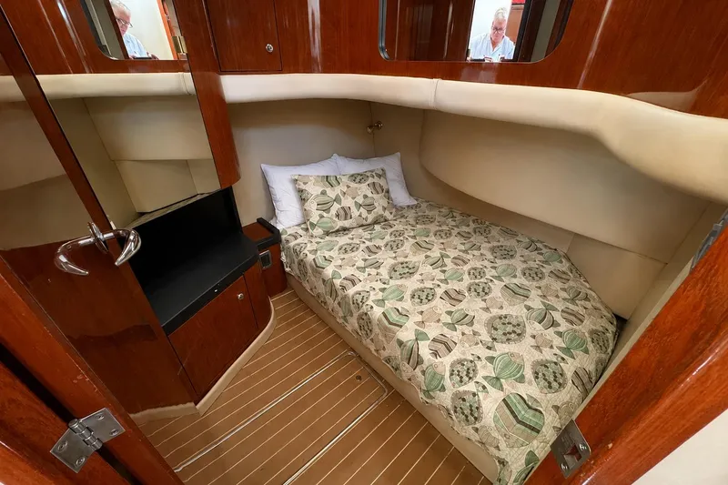 Slide: The Image of 2003 Sea Ray 45 Express Bridge cabin with cozy bed and wooden interior. - 16