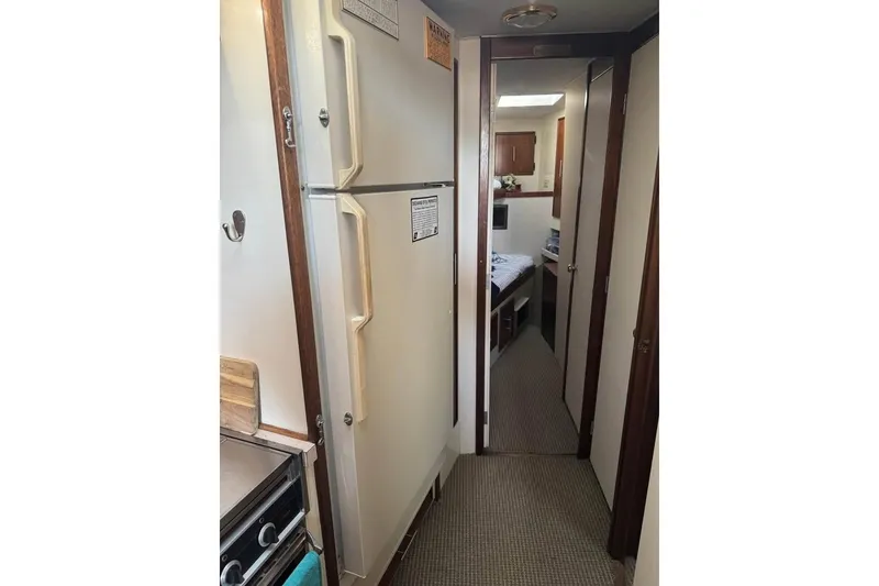 Slide: The Image of Interior view of a 1979 Post 42 Convertible yacht, featuring a compact kitchen and hallway. - 6