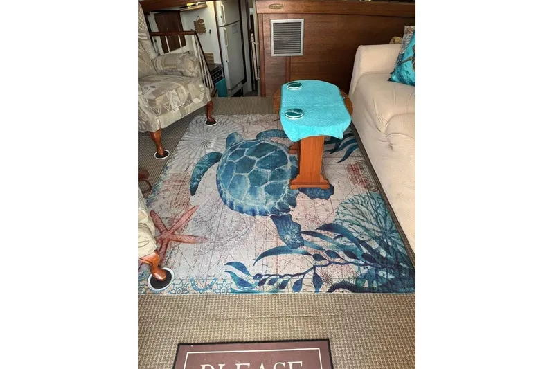 Slide: The Image of Interior of a 1979 Post 42 Convertible with turtle-themed rug and cozy seating. - 4