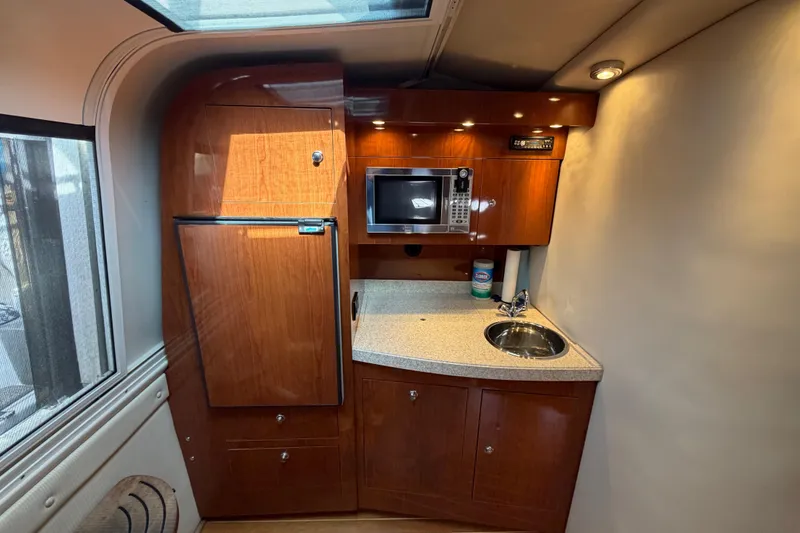 Slide: The Image of 2007 Regal Commodore 3760 IO boat kitchen with wood cabinets, microwave, and sink. - 30