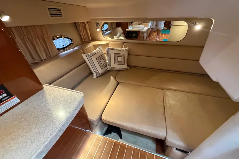 Slide: The Image of 2007 Regal Commodore 3760 IO interior with beige seating, decorative pillows, and wood accents. - 32