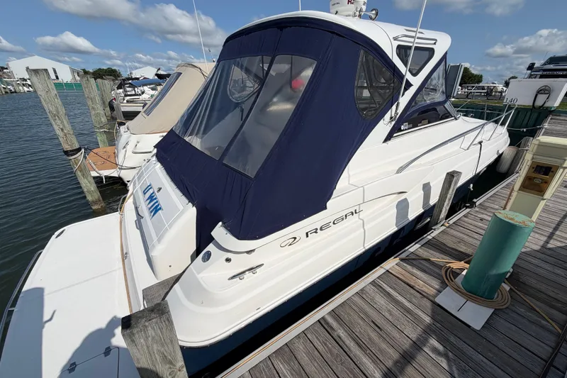 Slide: The Image of 2007 Regal Commodore 3760 IO yacht docked at marina under blue sky. - 4