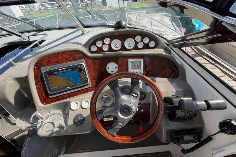 Slide: The Image of 2007 Regal Commodore 3760 IO boat dashboard with GPS, gauges, and wooden steering wheel. - 12