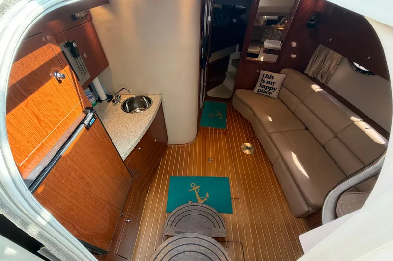 Slide: The Image of 2007 Regal Commodore 3760 IO interior with kitchenette, sofa, and nautical decor. - 26