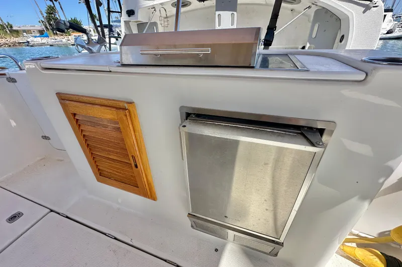 Slide: The Image of Outdoor kitchen area on a 2011 Ranger Tugs R-29 boat, featuring a grill and storage. - 14