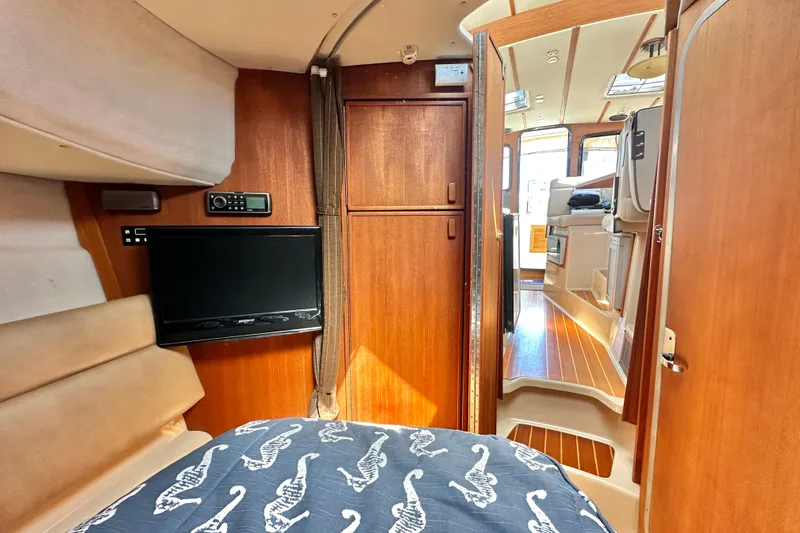Slide: The Image of 2011 Ranger Tugs R-29 cabin interior with wood paneling and cozy sleeping area. - 17