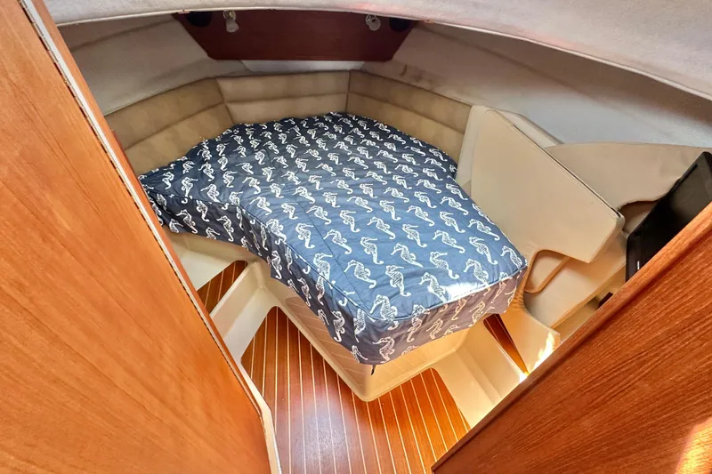 Slide: The Image of Cozy cabin interior of 2011 Ranger Tugs R-29 with patterned bedding and wood flooring. - 16