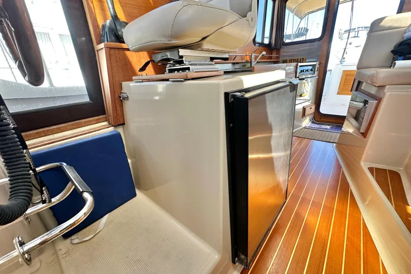 Slide: The Image of Interior of 2011 Ranger Tugs R-29 boat with wooden flooring and compact fridge. - 21