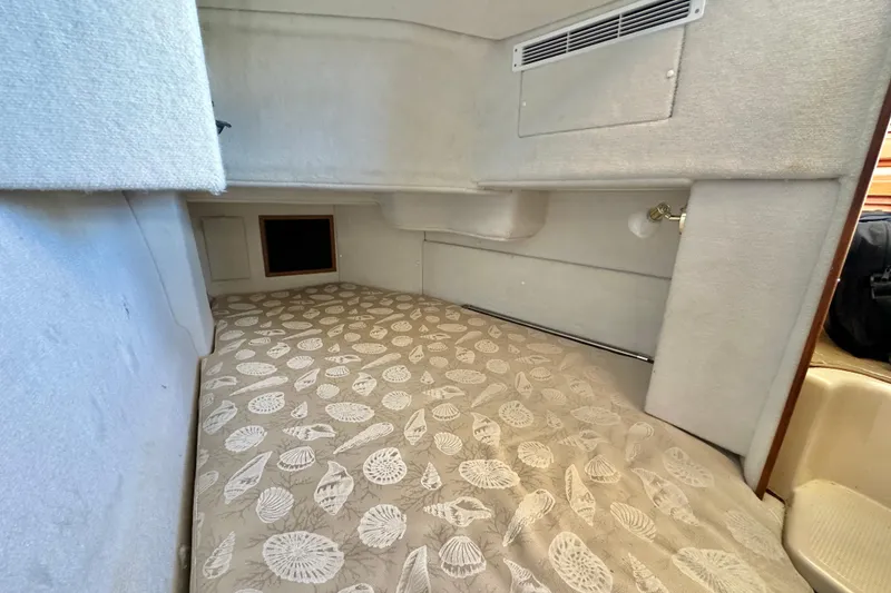 Slide: The Image of 2011 Ranger Tugs R-29 interior cabin with patterned bedding and beige walls. - 18