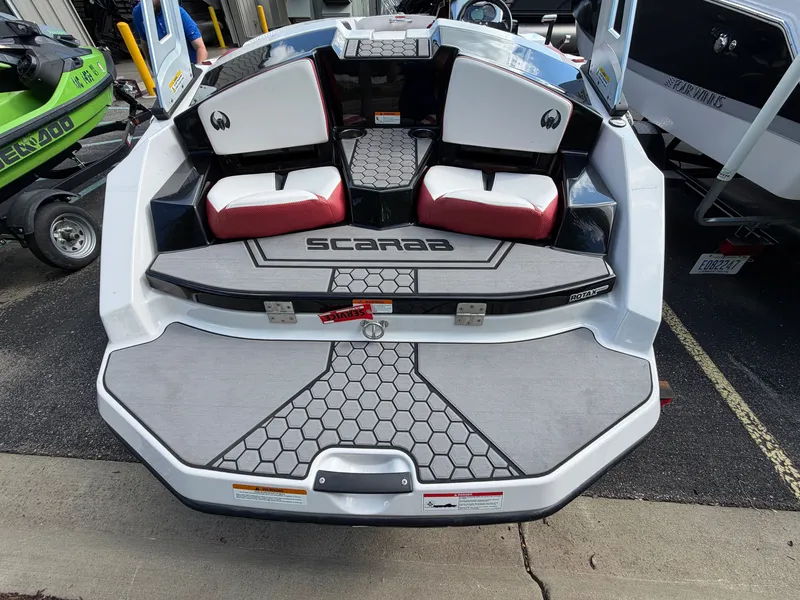 Slide: The Image of The image shows the rear of a 2017 Scarab 165 boat with red and white seats. - 4