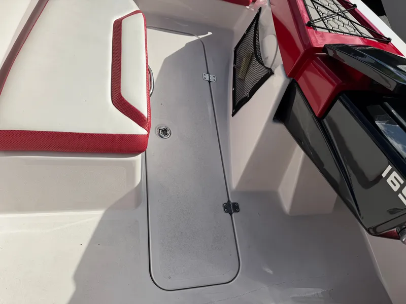 Slide: The Image of The image shows the cockpit of a 2017 Scarab 165 boat with red accents. - 19