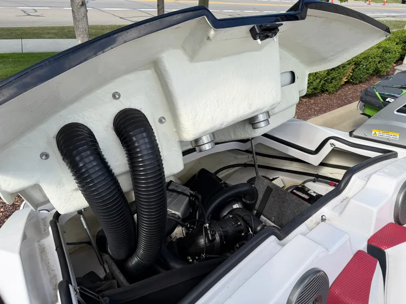 Slide: The Image of The engine compartment of a 2017 Scarab 165 with an open lid, showing hoses and engine. - 6
