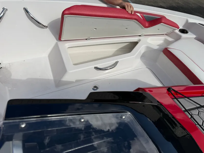 Slide: The Image of The image shows the cockpit of a 2017 Scarab 165 boat with red upholstery and storage space. - 14