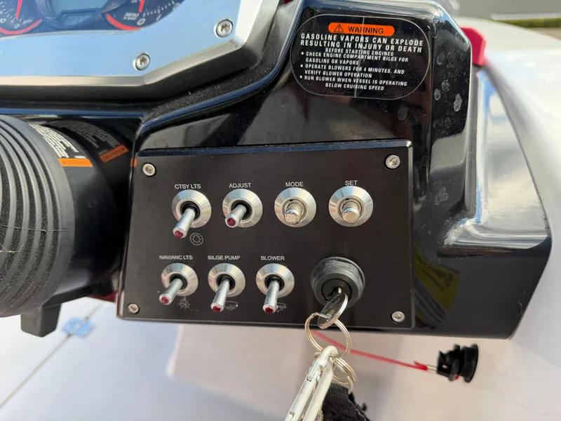 Slide: The Image of Dashboard of a Scarab 165 boat with switches and warning labels. - 11