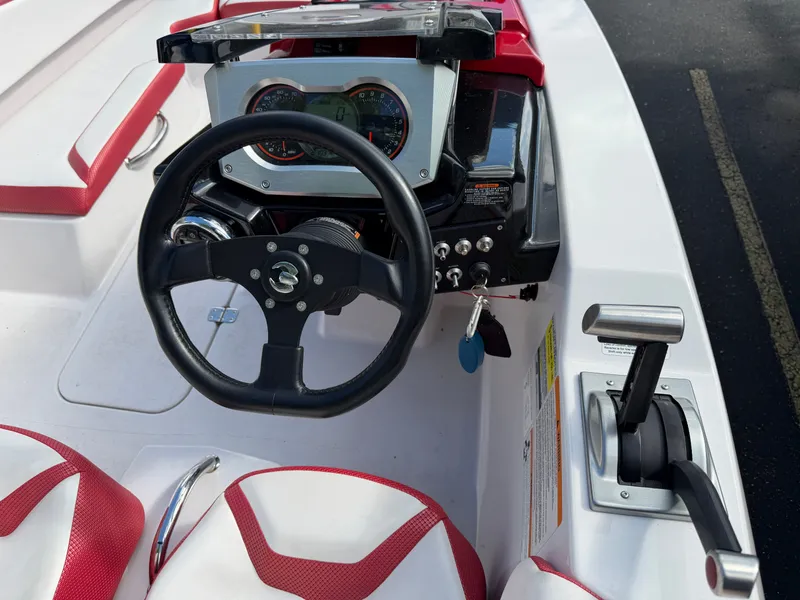 Slide: The Image of The image shows the cockpit of a 2017 Scarab 165 boat with steering wheel and controls. - 9