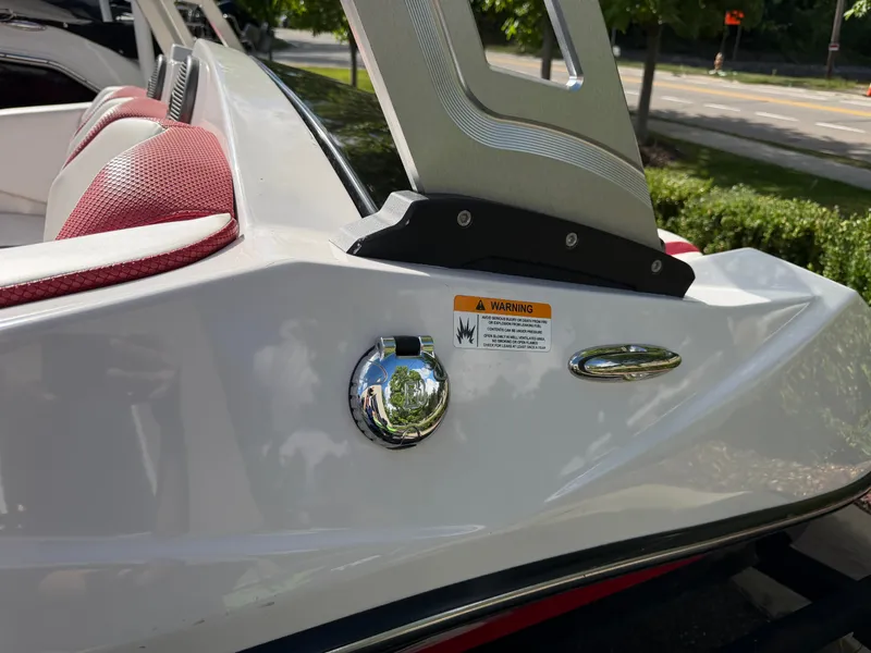 Slide: The Image of Close-up of a 2017 Scarab 165 boat, white with red seats and a warning label. - 21