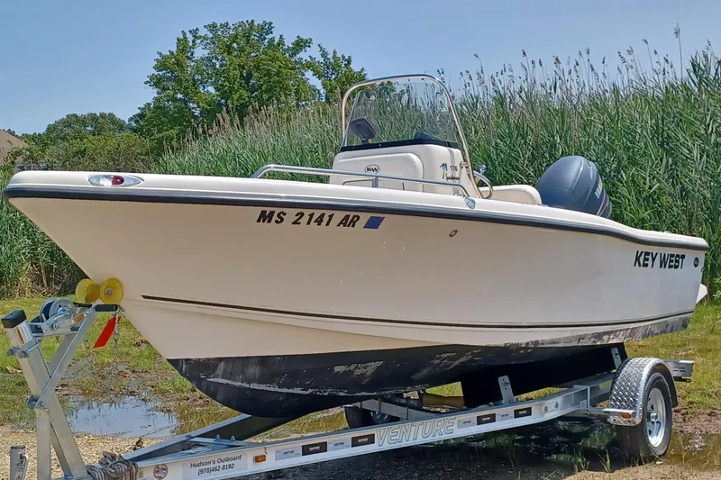 Slide: The Image of 2006 Key West 176 Sportsman CC boat on trailer, parked outdoors near tall grass. - 1