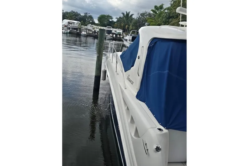 Slide: The Image of 2008 Sea Ray 40 Sundancer yacht docked, featuring blue covers and sleek design. - 3