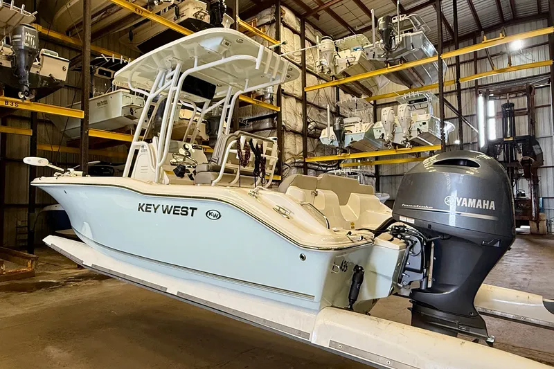 Slide: The Image of A 2023 Key West 219 FS boat in a storage facility, featuring a Yamaha outboard motor. - 2