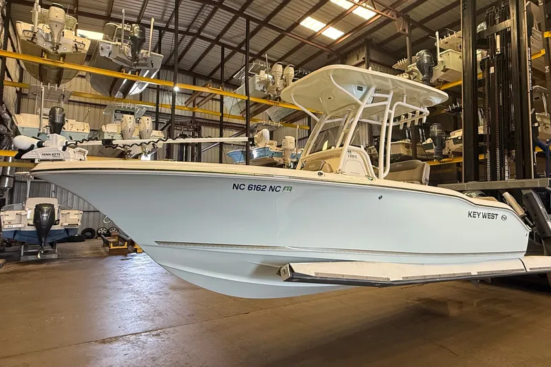 The Image of A 2023 Key West 219 FS boat in a warehouse, surrounded by other boats. - 0