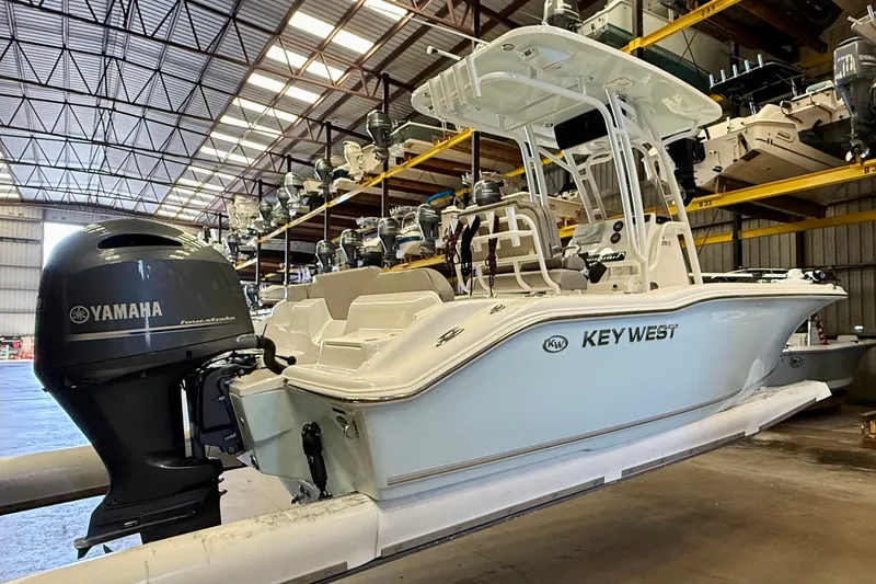 Slide: The Image of A 2023 Key West 219 FS boat in a warehouse. It features a Yamaha outboard motor. - 7