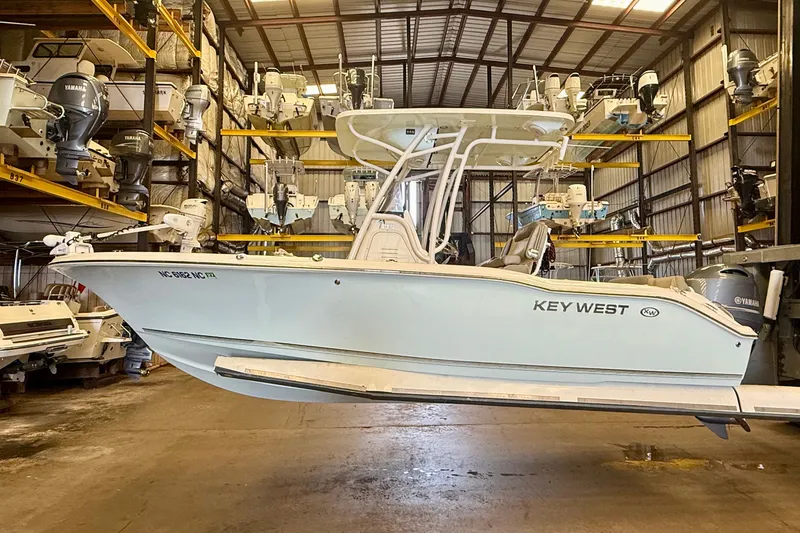 Slide: The Image of A 2023 Key West 219 FS boat in a warehouse, surrounded by other boats. - 1