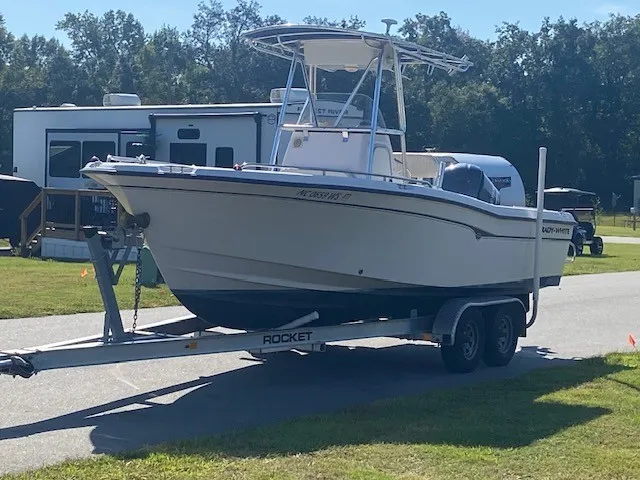Slide: The Image of A 2002 Grady-White 222 boat on a trailer, surrounded by RVs and trees. - 21