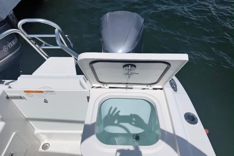 Slide: The Image of 2019 World Cat 320 DC boat with open hatch and Yamaha engine, docked on water. - 34