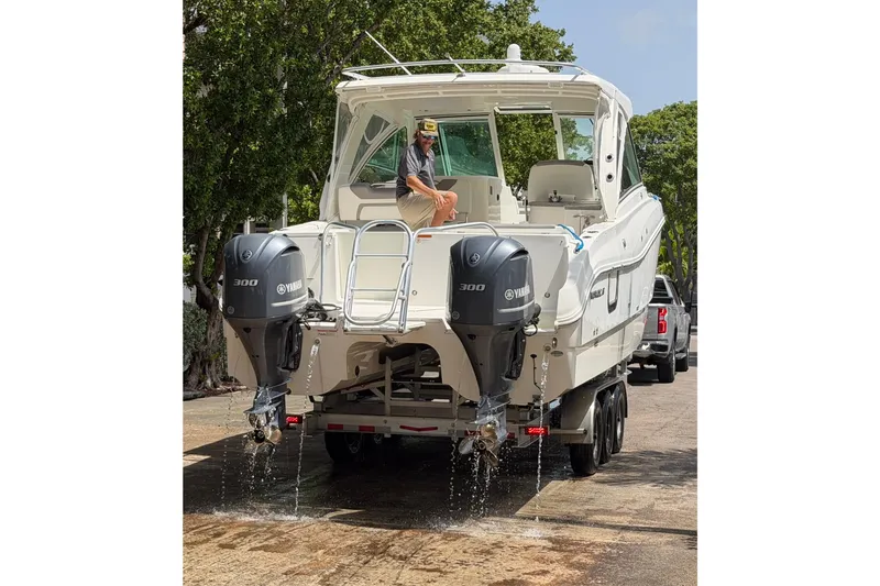 Slide: The Image of 2019 World Cat 320 DC boat on trailer with dual Yamaha engines, water draining. - 4