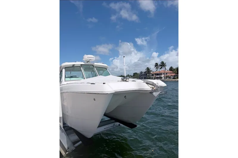 Slide: The Image of 2019 World Cat 320 DC boat docked on water with clear blue sky background. - 11
