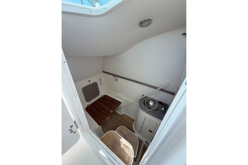 Slide: The Image of Interior of 2019 World Cat 320 DC boat, featuring a compact cabin with sink and seating. - 18