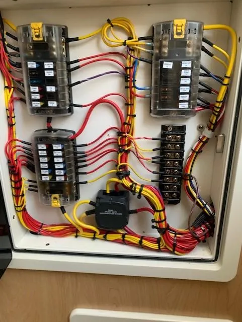 Slide: The Image of An electrical panel with colored wires and fuses inside a boat. - 23