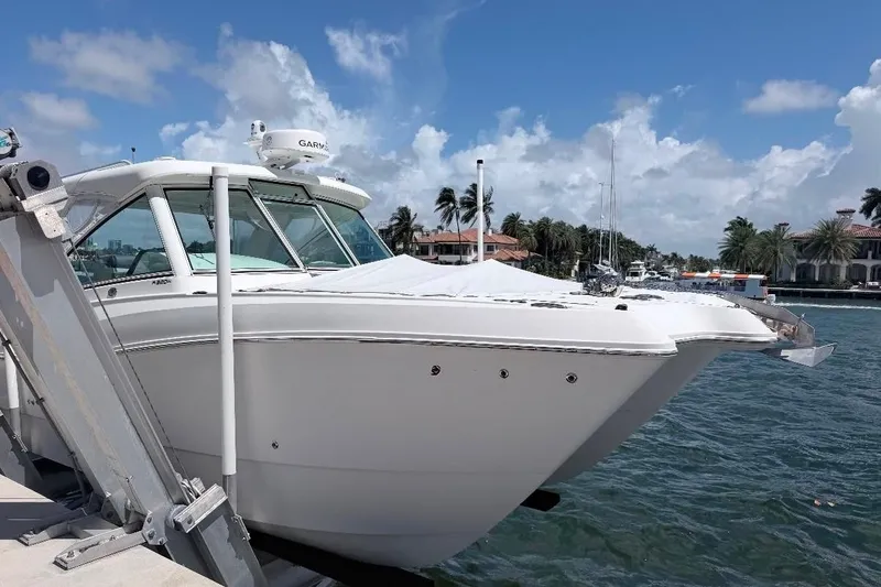 Slide: The Image of 2019 World Cat 320 DC boat docked by waterfront homes under a clear blue sky. - 10