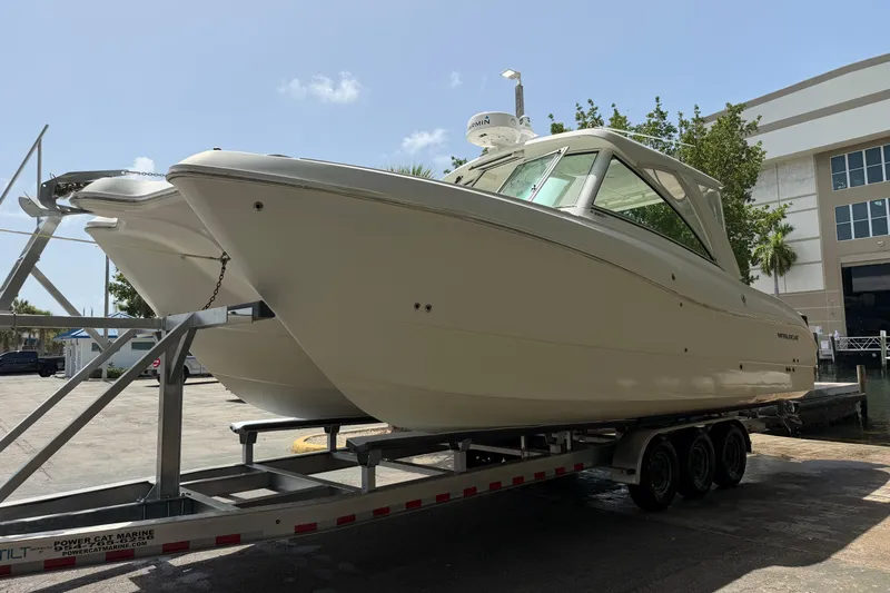 Slide: The Image of 2019 World Cat 320 DC boat on trailer, parked outdoors near a building. - 5