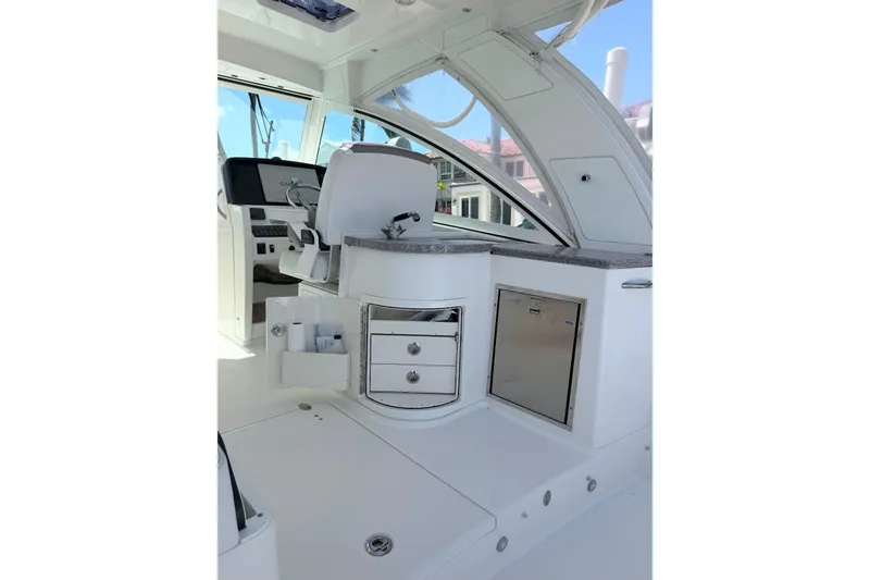 Slide: The Image of Interior of 2019 World Cat 320 DC boat, featuring helm station and storage compartments. - 25