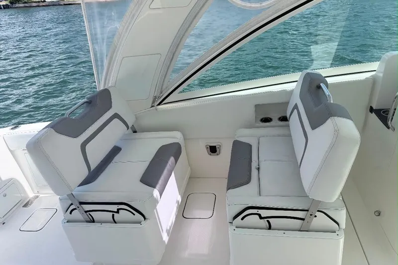 Slide: The Image of 2019 World Cat 320 DC boat interior with cushioned seating and ocean view. - 30