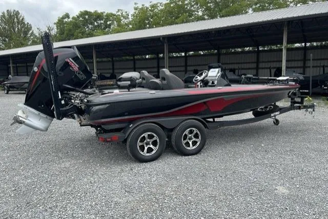 Slide: The Image of 2024 Nitro Z19 boat with dual-axle trailer, parked outdoors on gravel. - 10