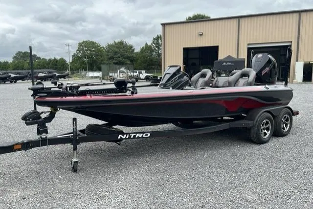 Slide: The Image of 2024 Nitro Z19 boat on trailer, parked outdoors near a warehouse. - 8