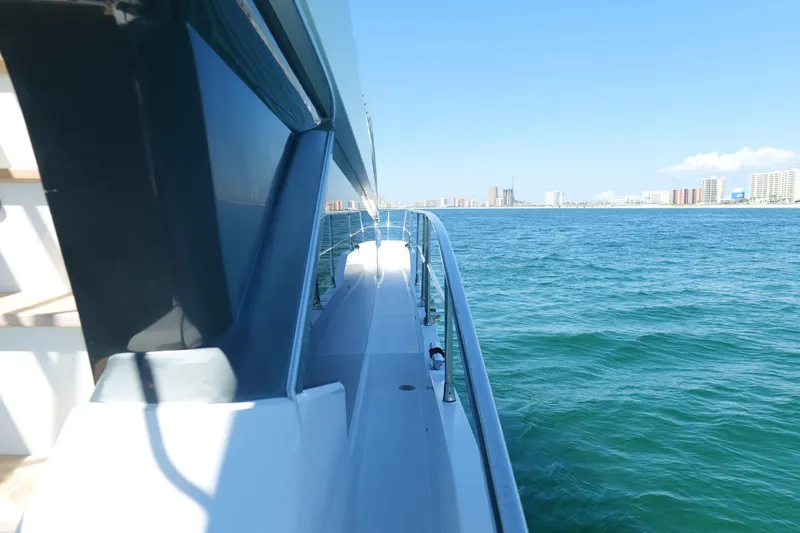 Slide: The Image of Pearl 62 yacht cruising on blue ocean near city skyline, 2022 model. - 60