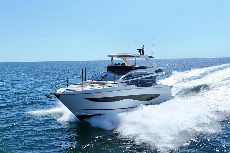 Slide: The Image of Luxurious 2022 Pearl 62 yacht cruising on open sea under clear blue sky. - 76