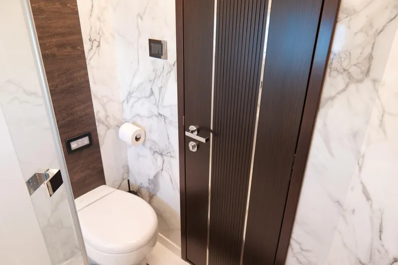 Slide: The Image of Modern bathroom with marble walls, wooden door, and toilet in Pearl 62, 2022 model. - 39