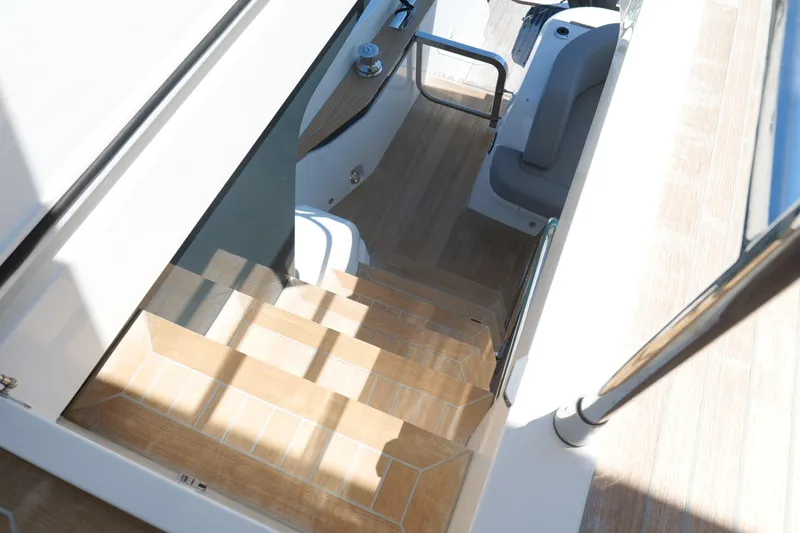 Slide: The Image of Staircase on 2022 Pearl 62 yacht, featuring sleek wooden design and modern interior. - 56